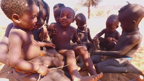 NAMIBIA - CIRCA 2018 - Cute Himba tribal children of Africa play happily in slow motion.