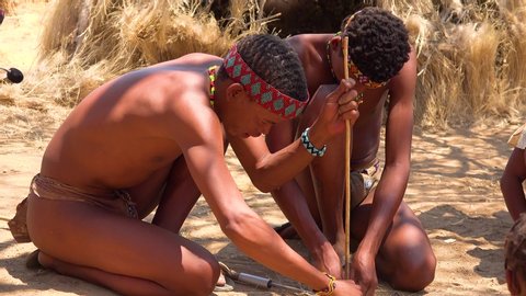 NAMIBIA - CIRCA 2018 - African San tribal bushmen make fire the traditional way in a small, primitive village in Namibia, Africa.