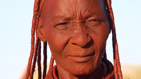 NAMIBIA - CIRCA 2018 - Extreme close up portrait of a Himba tribal African woman face with mud dreadlocks hair and neck ring jewelry.