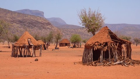 NAMIBIA - CIRCA 2018 - Small poor African Himba rural village on the Namibia Angola border with mud huts, goats and children.