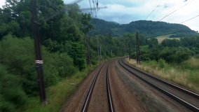 Back view of railroad train branching pass with beautiful green nature and mountains view along the road. 4k video
