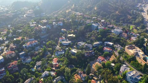 Griffith observatory, Aerial, drone shot, tilting over building in a park towards mount Hollywood, on a sunny, summer day, in Los Feliz, Los Angeles, USA