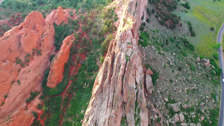Aerial, drone shot, panning over the famous, red sandstone mountains, at the Garden of the Gods park, on a sunny evening, in Colorado springs, USA
