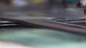 Rubber tape with color markings cut on pieces moves on a conveyer belt, close up. Rubber band before molding at a tire factory. - Powered by Shutterstock - Get 15% off with code: PIKWIZARD15