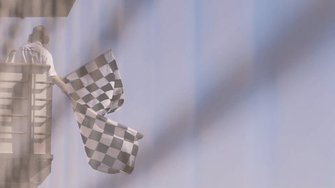 Man waving checkered race flag in slow motion at finish line on a raceway