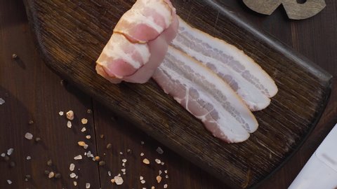Chef makes rolls with bacon and chicken chest on the dark wooden board in the kitchen, close up shot of cooking meat, preparing chicken for grilling, Full HD Prores 422 HQ