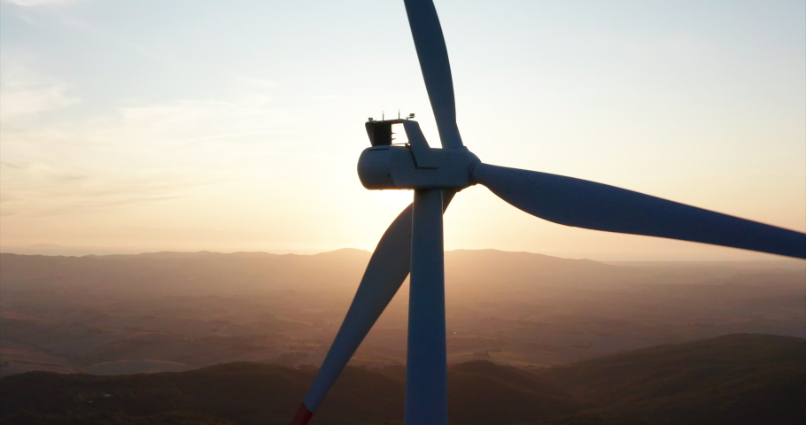 Aerial close up shot of wind mills rotating by the force of the wind and generating renewable energy in a green ecologic way to the planet on a sunset. Royalty-Free Stock Footage #1035507986