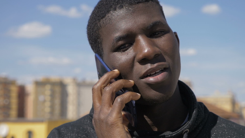 Handsome american african youg man talking by phone.Youth,communucation-outdoor