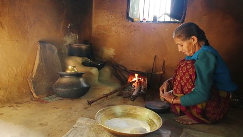 a Indian village women making bread [ chapati] in Indian traditional stove.