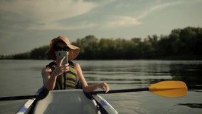 Woman Taking Selfie On Kayak Boat On Evening.Girl Making Self Photo And Answer To Video Call.Holiday Vacation Trip On Weekend.Happy Adventure Activity.Beautiful Place On Tranquil Water Pond At Sunset.