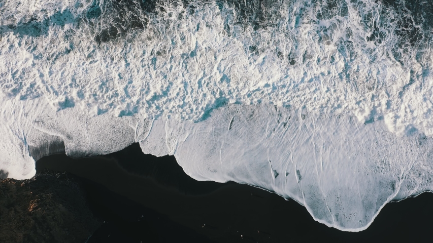Storm on a black beach, top view drone. Static frame 4K UHD