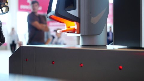 Close-up of people passing electronic turnstile with barcode scanner. Media.Electronic access control indoor security system side view