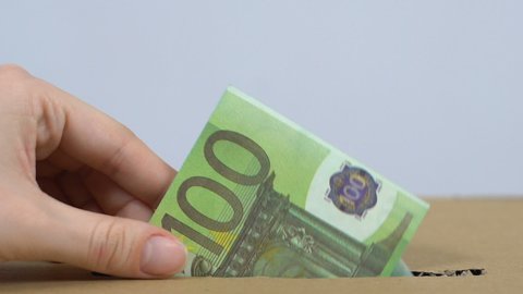 Volunteer hand throwing euro banknote in box, donating money to charity, aid