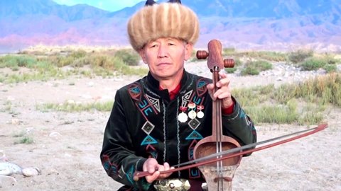 Issyk Kul, Kyrgyzstan  -  2017 05 28  -  Man Plays Traditional Komuz Two Stringed Instrument