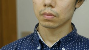 Japanese man touching stubble in the bathroom