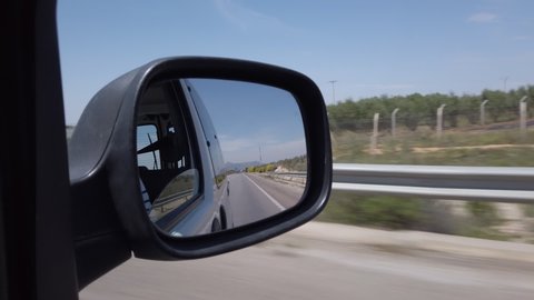 View through the side mirror of the landscape that passes between Fes and Meknes on the highway in Morocco.