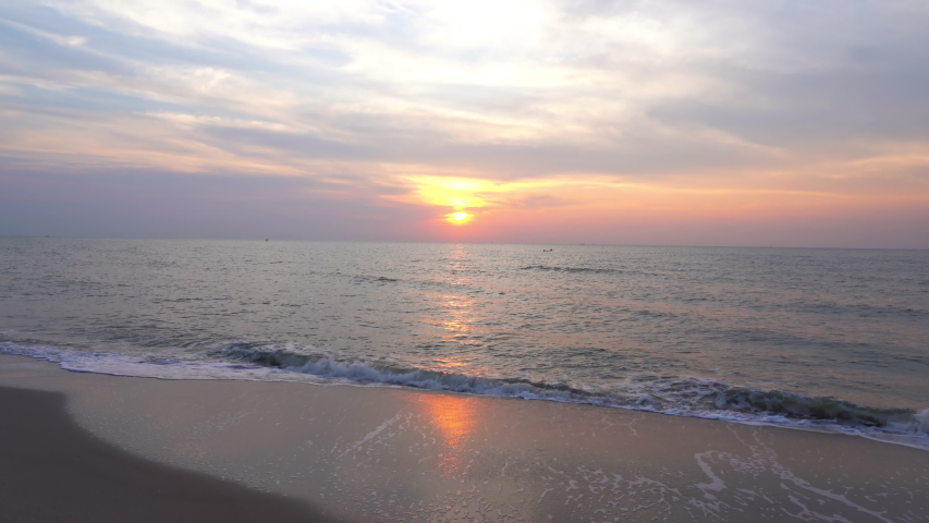 A serene golden hour beach with beautiful and calm sea waves.
