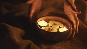 Thai massage spa ritual. Bali life style. Prayer ceremony. Ayurveda medicine. Hands put aroma bowl with oil.  Floating candles and frangapani flower in water. Couple practice. Relaxing therapy.  - Powered by Shutterstock - Get 15% off with code: PIKWIZARD15