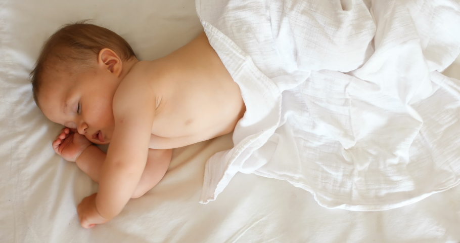 Peaceful adorable baby sleeping on his bed in a room at home. Soft focus. Sleeping baby concept. 1 year-old babyboy sleeps at home, top view | Shutterstock HD Video #1035578045