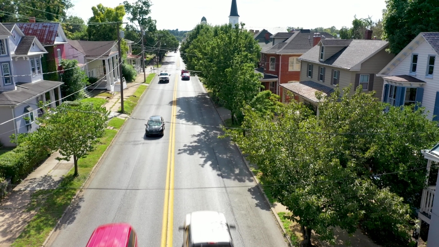 Asecending over a busy main street in Charles Town, West Virginia with churches in the distance. Royalty-Free Stock Footage #1035584150