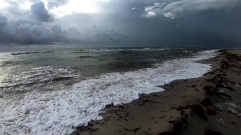 Slow motion waves hitting fine sand shore on cloudy day, Miami beach, Florida