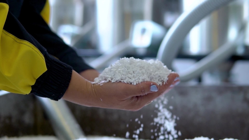 Plastic granules are poured from the hand. Plastic granules, dye, polymer granules are used for the production of plastic products | Shutterstock HD Video #1035589022