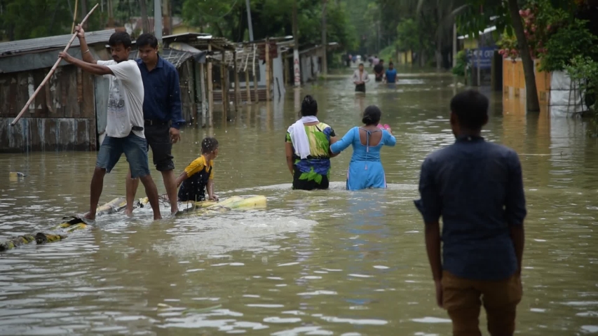 Barpeta, Assam, India. 18 July 2019. Villagers wade through flood water after Pahumara river overflowed at Pathsala.