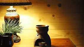 The creative process of preparing items for shooting video and photos. The real statement of the correct composition and lighting. Aroma lamp, pine branch and lamp close-up.
