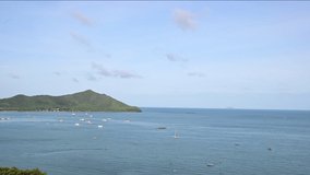 Moving cloud under the beautiful blue sky time lapse video with fisherman boats along the ocean and mountain background. 