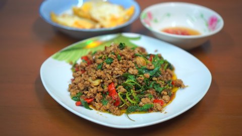 Close up Stir fried Minced pork with basil and fried egg and fish sauce dip background 
fast food Thai Style food. Thailand street food. Thailand's national dishes, Thai name is Pad kra prao Mou.