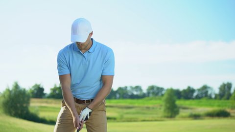 Inexperienced golf player hitting ball, shocked with failed shot, loser concept