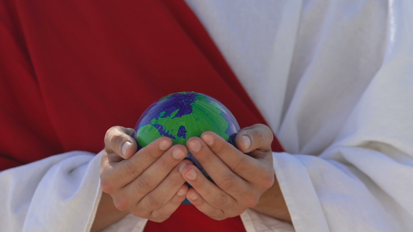 Man in arabic clothing holding small globe, religious stories of world creation
