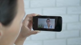 Video call to the doctor. Woman communicates with doctor in video calls on smartphone.