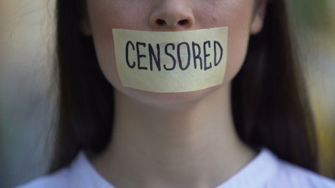 Woman taking off tape with censored word over mouth, democracy concept, freedom