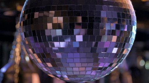 close up shot of shiny spinning disco ball with silver reflection