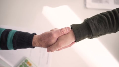Slow motion top view shot of two men shaking hands