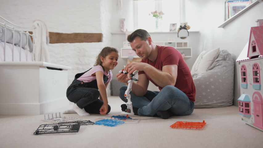 Father And Daughter In Bedroom Building Robot Kit Together | Shutterstock HD Video #1035638072