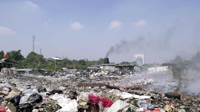 Landfill with a lot of trash and smoke near Jakarta area. There're a lot of pollution in this site. People burn everything and let it be inhaled by everyone. Royalty-Free Stock Footage #1035638972
