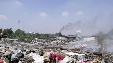 Landfill with a lot of trash and smoke near Jakarta area. There're a lot of pollution in this site. People burn everything and let it be inhaled by everyone.
