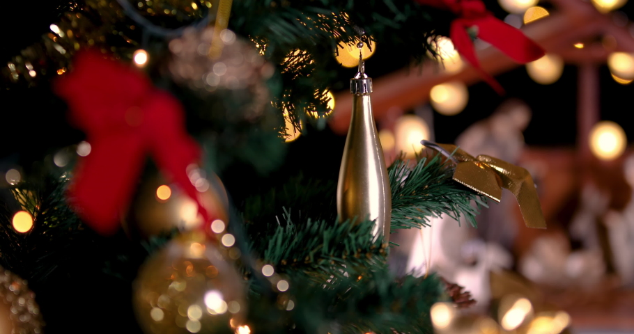 Jesus Christ Nativity scene with atmospheric lights near Christmas tree. Christmas scene. Focus is moving from Christmas tree to manger. Dolly shot 4k