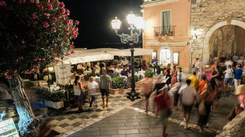 Timelapse of Tourists strolling around IX Aprile square in Taormina by night Sicily Italy August 2019