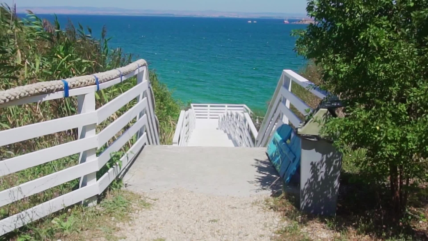 Walking Toward the Sea on a White Fenced Stairway