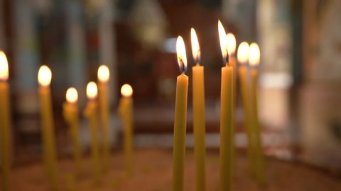 Madaba / Jordan - 01 11 2019: Madaba, Jordan, January 2019 - Slow Motion of Thin Yellow Burning Candles Set With Barely Visible Interior of Madaba St George's Greek Orthodox Church