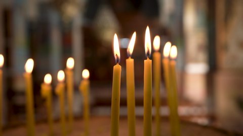 Madaba / Jordan - 01 11 2019: Madaba, Jordan, January 2019 - A Thin Long Yellow Candles Burning Inside of the Madaba St George's Greek Orthodox Church with Blurred Background