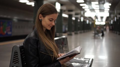 Beautiful Girl Reading Book On The Train Station While Waiting For The Train