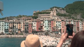 Tourist taking picture and videos of a small village in Italy