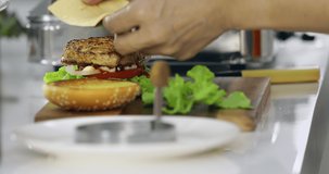 Close up scene video of man's hand putting some cheese on burger and cover it by bun, it look delicious.
