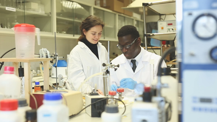 Portrait of proffesional male and female lab cientists in interior of laboratory