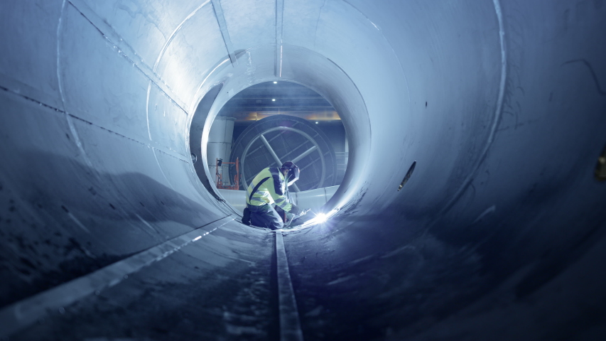 Professional Heavy Industry Welder Working Inside Pipe, Wears Helmet and Starts Welding. Construction of the Oil, Natural Gas and Fuels Transport Pipeline. Industrial Manufacturing Factory.Slow Motion | Shutterstock HD Video #1035704192