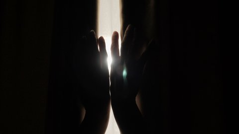 Female Hands Open Window Curtain in Morning. Slow Motion. Young Woman Opening Curtains in a Bedroom. Close up. Hands Pulling a Window Curtain for Warm Morning Light.